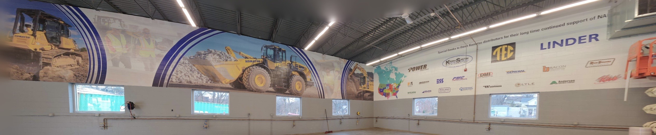 Large commercial wall graphics featuring construction equipment and distributor branding